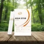 ซองบุหรี่ Asia Star Classic สีขาวทองและมวนบุหรี่วางบนโต๊ะไม้ในบรรยากาศป่าไม้สีเขียว